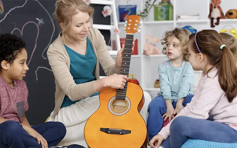 nursery teacher playing guitar